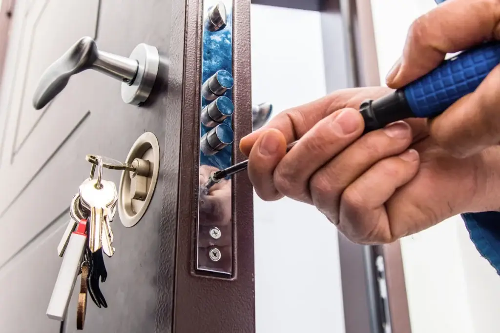 Cerrajero instalando una cerradura de alta seguridad en una puerta típica de departamento en Santiago