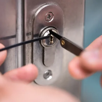 Cerrajero profesional abriendo una cerradura con ganzúas en primer plano, sin dañar la puerta